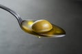 Olive oil with olive fruit in spoon