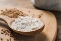 Spoon with wheat flour and grains on wooden board, closeup Royalty Free Stock Photo