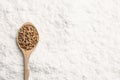 Spoon with wheat grains on flour, top view. Space for text Royalty Free Stock Photo