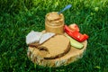 Spoonful of peanut butter on wooden plate with meat sandwiches