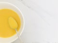 A spoonful of pumpkin soup, on a white marble background. copy space.