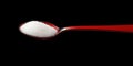 Spoonful of White Sugar on Red Spoon Isolated on Black Background for Culinary Use Royalty Free Stock Photo