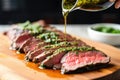 spooning chimichurri sauce on grilled flank steak