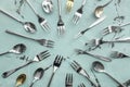 Spoons and forks on color background, flat lay Royalty Free Stock Photo