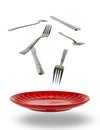 Spoons, forks, knife and red plate levitation Royalty Free Stock Photo