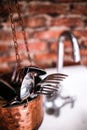 Spoons and forks are put in containers that hang in the sink. Royalty Free Stock Photo
