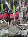 Spoons, ladles and other cooking utensils are hung and displayed for sale.