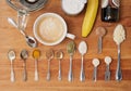 Spoons and spices to prepare a super coffee: a cup and a blender on a wooden chopping board with banana, MCT oil, turmeric, black