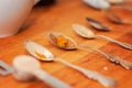 Spoons and spices on a wooden chopping board: spices like turmeric, black pepper, chili, cinnamon, maca, cardamom and ashwagandha