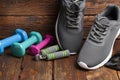 Colored dumbbells and sport shoes on wooden background