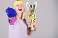 Sport achievement. Celebrate victory. Boxing champion. Athletic girl boxing glove and golden goblet. Woman wear sport