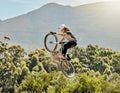 Sport, action and biker doing jump in air with mountain bike for extreme sports, adrenaline and hobby. Fitness Royalty Free Stock Photo