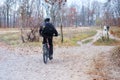 Sport and active healthy life concept. Cyclist in protective late fall forest. Riding on bike on sunny day among many trees