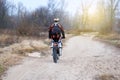 Sport and active healthy life concept. Motorcyclist in protective late fall forest. Riding on motorcycle on sunny day among many