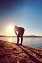 Sport active man running and exercising on the beach at sunset. Royalty Free Stock Photo