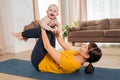 Postnatal recovery. Mom practicing yoga with her infant baby at home Royalty Free Stock Photo