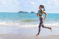 Sport aisan woman running barefoot on beach . Fitness runner female wearing sportswear jogging on sea background outdoor. fit Royalty Free Stock Photo