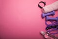 Sport and athletics, dumbbell and skipping rope with a fitness bracelet on a pink background. Copy space for text