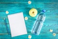 Sport background: notebook, bottle of water and apple on blue wooden background. Fitness, healthy lifestyle, plan of workout Royalty Free Stock Photo