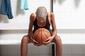 Sport basketball player in the locker room, a African American female athlete holding the ball before the game, competition or