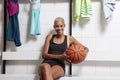 Sport basketball player in the locker room, a smiling African American female athlete holding the ball before the game, Royalty Free Stock Photo