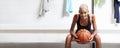 Sport basketball player in the locker room, a smiling African American female athlete holding the ball before the game, Royalty Free Stock Photo