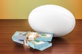 Sport bets. Rugby ball with dollar packs on the wooden table, 3D rendering