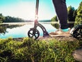 Sport body boy stay on push scooter on edge at pond Royalty Free Stock Photo