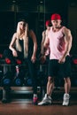 Sport, bodybuilding, weightlifting, lifestyle and people concept - Young beautiful couple in stylish clothes sitting a Royalty Free Stock Photo