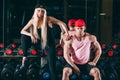 Sport, bodybuilding, weightlifting, lifestyle and people concept - Young beautiful couple in stylish clothes sitting a Royalty Free Stock Photo