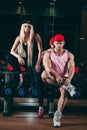 Sport, bodybuilding, weightlifting, lifestyle and people concept - Young beautiful couple in stylish clothes sitting a Royalty Free Stock Photo