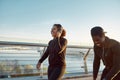 Sport that brings happiness. Young happy african couple in sportswear and headphones jogging together on the bridge in Royalty Free Stock Photo