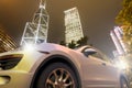 A sport car on motion in front the skyline of Hong Kong