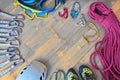 Sport climbing gear with space for text in the middle - top down view, wooden background. Set of: quickdraws, helmet, harness.