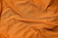 Sport clothing fabric texture background. Top view of orange polyester nylon cloth textile surface. Colored basketball shirt with Royalty Free Stock Photo