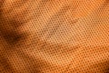 Sport clothing fabric texture background. Top view of orange polyester nylon cloth textile surface. Colored basketball shirt with Royalty Free Stock Photo