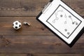 Sport coach concept. Pad with tactic plan of the match near whistle and football ball on wooden background top view copy Royalty Free Stock Photo