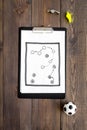 Sport coach concept. Pad with tactic plan of the match near whistle and football ball on wooden background top view copy Royalty Free Stock Photo