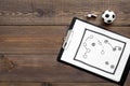 Sport coach concept. Pad with tactic plan of the match near whistle and football ball on wooden background top view copy Royalty Free Stock Photo