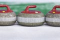 Sport Concepts. Closeup of Curling Blue Handle Stones on Ice.