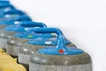Sport Concepts. Closeup of Curling Blue Handle Stones on Ice.