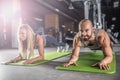 Sport couple doing plank exercise workout in fitness centrum. Man and woman practicing plank in the gym Royalty Free Stock Photo