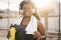 Sport curvy black woman listening music with headphones - Focus on face