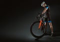 Sport. Cyclist carry a bike on black background.