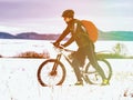 Sport cyclist pushing bike in hardest and snowy landscape during winter