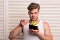 Man pretends to eat noodles on light wooden background