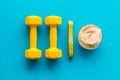 Sport diet. Protein shake near dumbbells on blue background top-down flat lay Royalty Free Stock Photo