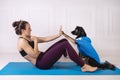 Sport with a dog. Attractive girl working out on the blue fitness mat with her dog. Athletic woman doing exercise Royalty Free Stock Photo