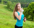 Sport, exercise and healthcare - sporty girl with water bottle. Young beautiful woman drinking water after fitness exercise Royalty Free Stock Photo