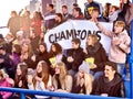 Sport fans holding champion banner on tribunes